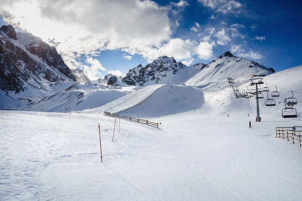 Skiers going down the slope under ski lift. stock photo