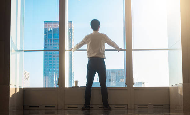 istock Businessman looking city through the window 503520084