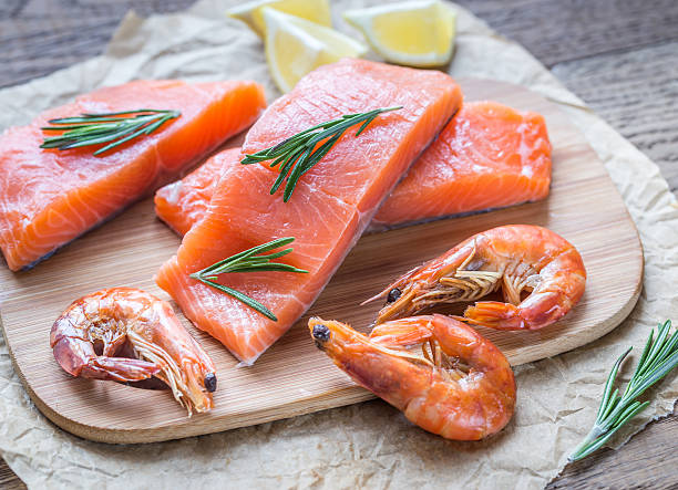 Raw salmon with shrimps on the wooden board Raw salmon with shrimps on the wooden board omega 3 and 6 stock pictures, royalty-free photos & images