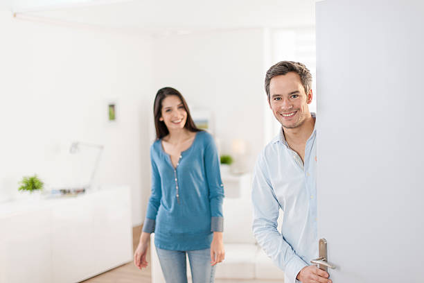 istock Cheerful couple inviting people to enter in home 503522859