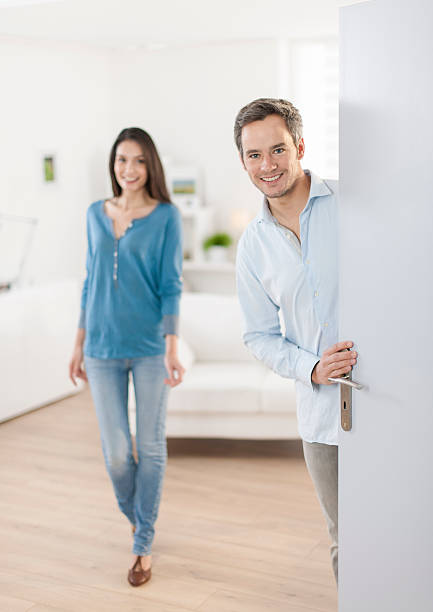 istock Cheerful couple inviting people to enter in home 503523405