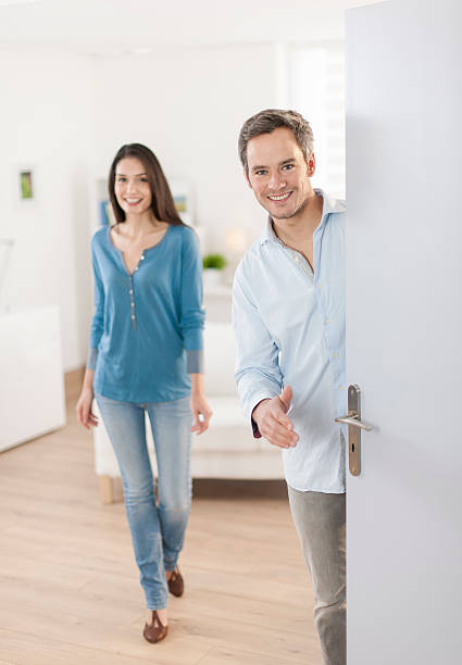 istock Cheerful couple inviting people to enter in home 503523407