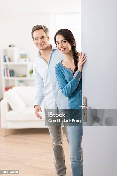 Cheerful Couple Inviting People To Enter In Home Stock Photo - Download Image Now - 30-34 Years, Adult, Beautiful People