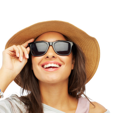 Shot of an attractive young woman wearing a hat and sunglasses isolated on white