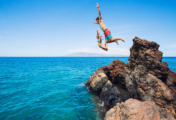 istock Friends cliff jumping into the ocean 503529193