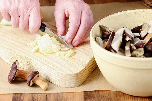 cutting cebollas de comida tipo seta - maronenröhrling fotografías e imágenes de stock