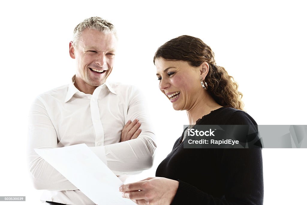 Smiling male and female colleagues discussing a document A smiling man looks down at documents held by his female collegue who also looks happy. 20-29 Years Stock Photo