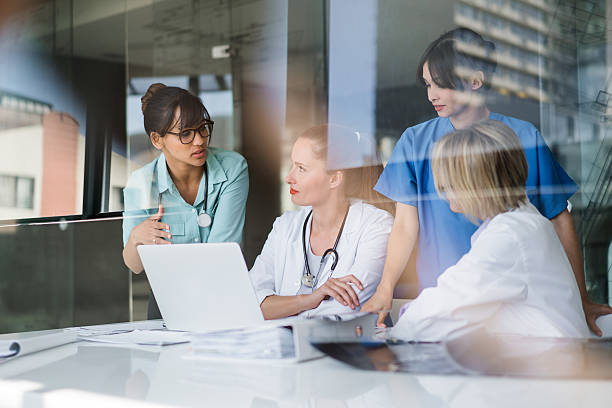 Female doctors discussing at laptop desk