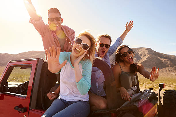 istock Friends On Road Trip Standing In Convertible Car 503535722