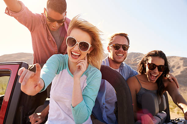 istock Friends On Road Trip Standing In Convertible Car 503535788