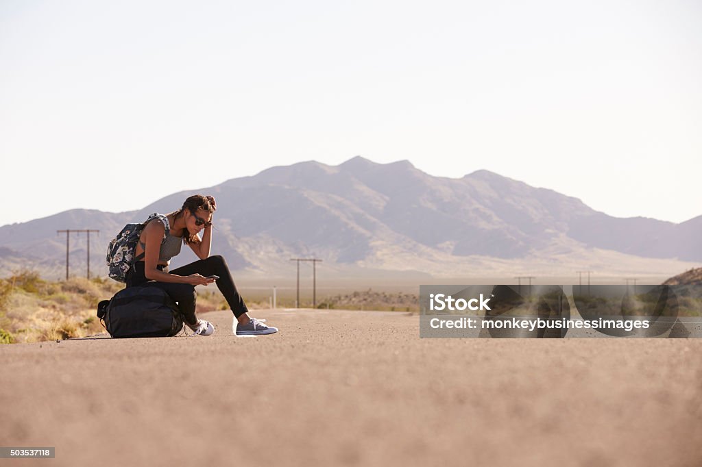 Woman On Vacation Hitchhiking Along Road Using Mobile Phone 20-29 Years Stock Photo