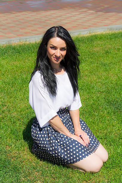 istock Brunette sitting on green grass 503541068