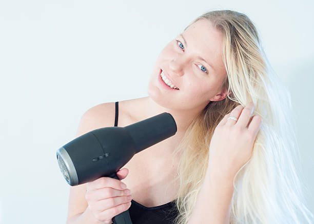 istock Blond woman blowdrying hair 503545816