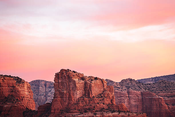 Red rock land formation in wilderness desert canyon under an unusual pastel sunrise sky, Sedona, Arizona.