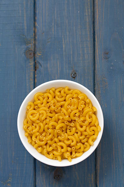 istock dry pasta in white bowl on blue wooden background 503547132