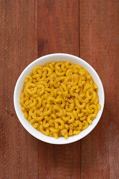 istock dry pasta in white bowl on brown wooden background 503547166
