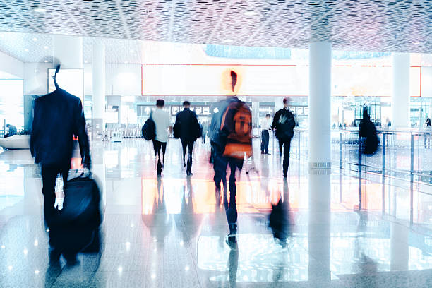 mouvement flou les voyageurs modernes dans un couloir de marche de l'aéroport - commercial airplane airport arrival departure board business travel photos et images de collection