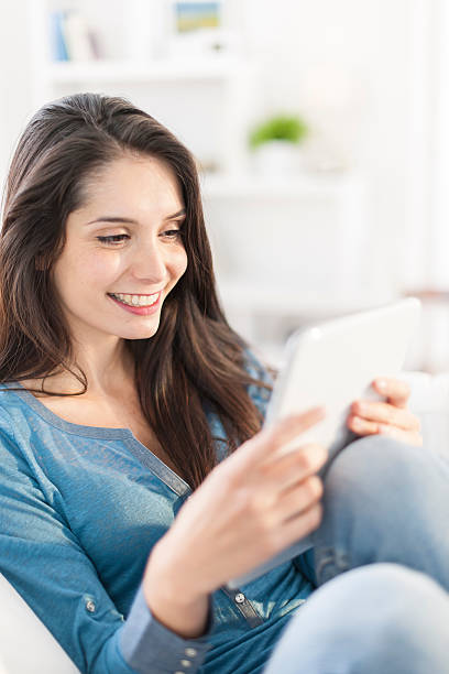 istock beautiful young woman using digital tablet on a sofa 503564947