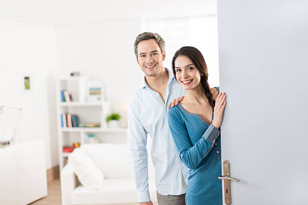 istock Cheerful couple inviting people to enter in home 503565061