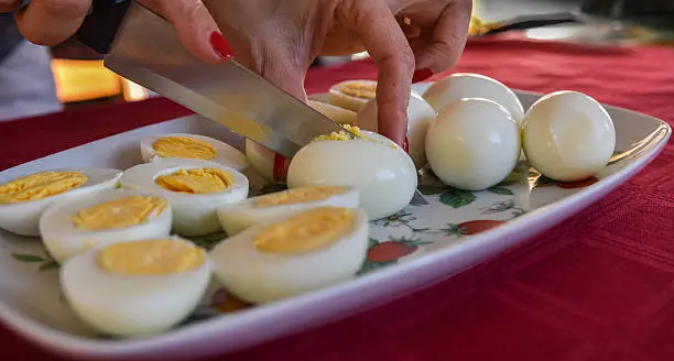 Woman preparing breakfast, boiled eggs cut in half