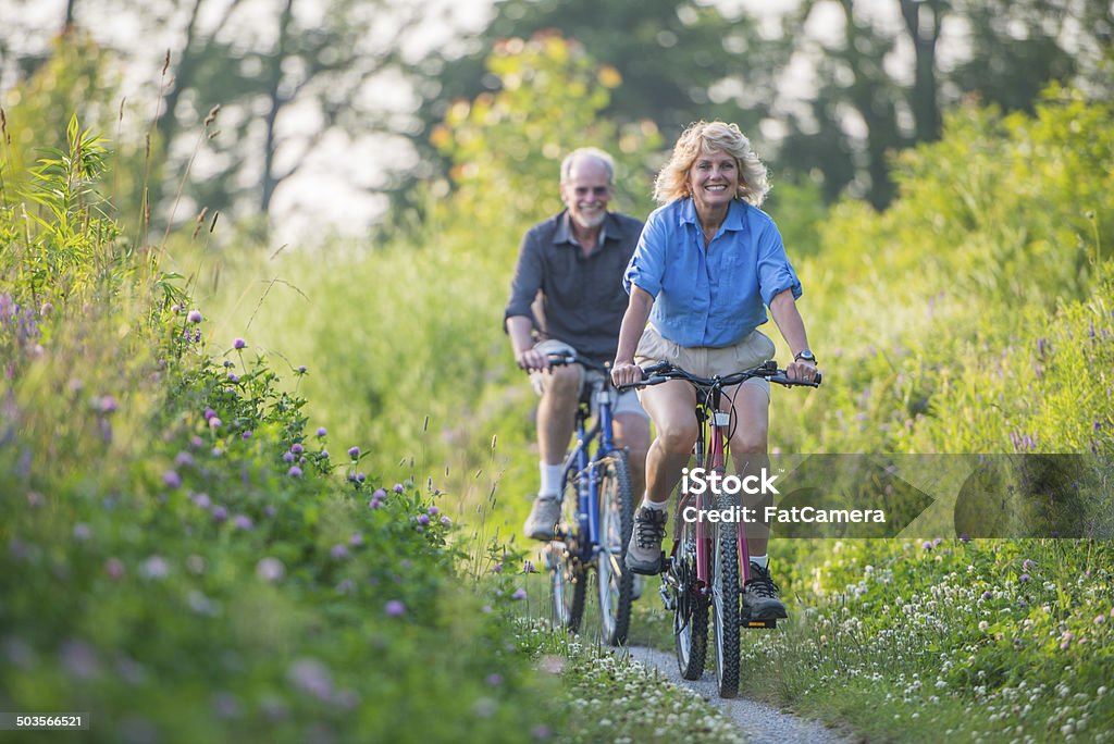 Senior couple biking Senior couple biking outdoors Cycling Stock Photo