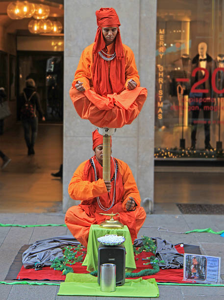 Street performers are showing a magical trick, levitation in the Milan, Italy - November 27, 2015: Street performers are showing a magical trick, levitation in the air indian levitation trick stock pictures, royalty-free photos & images
