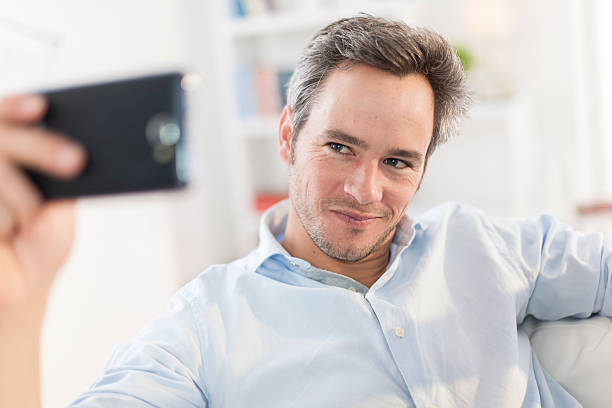 istock handsome man taking a humoristic selfie with his phone 503569451