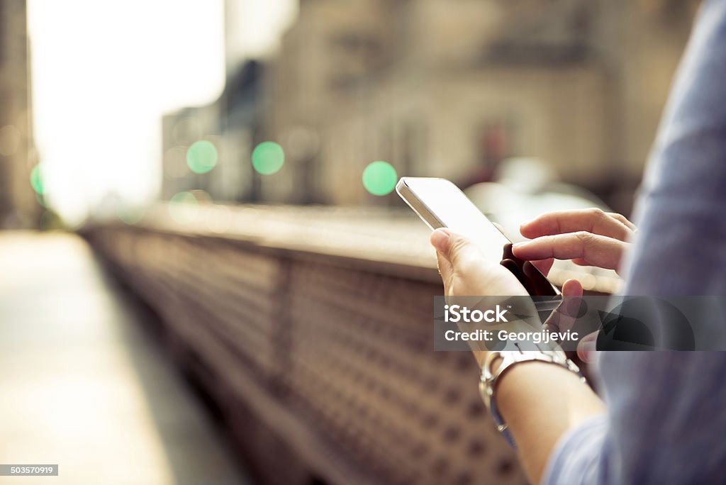 smartphone Casual woman typing on the smartphone in the city. Connection Stock Photo