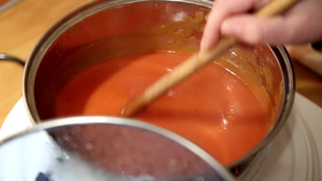 Cook Adding Spices Into Red Sauce