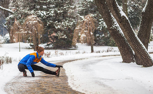 giovane donna sportiva facendo esercizi durante l'allenamento invernale fuori in - beautiful caucasian teenager running foto e immagini stock