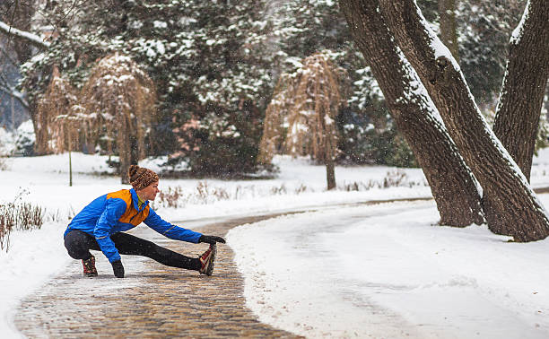 Young sport woman doing exercises during winter training outside in stock photo