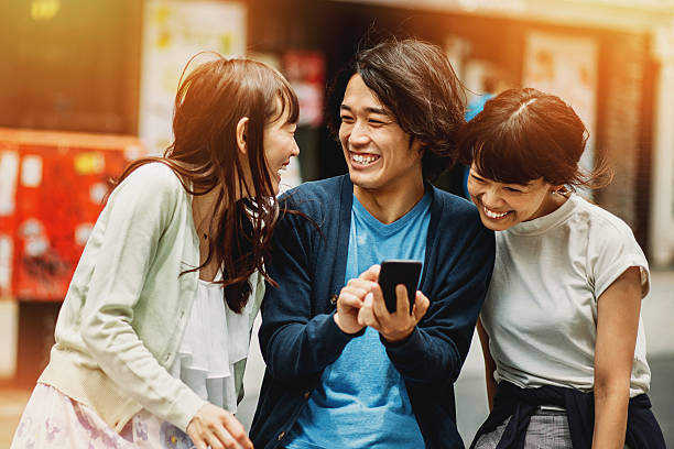 gruppe von jungen mit smartphone japanischen personen - photographing smart phone friendship photo messaging stock-fotos und bilder