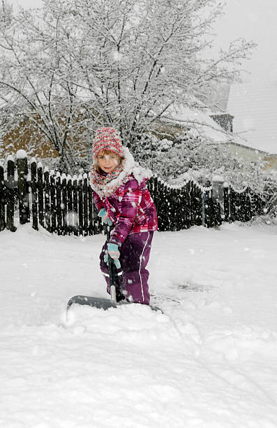 istock girl with snow shovel 503581344
