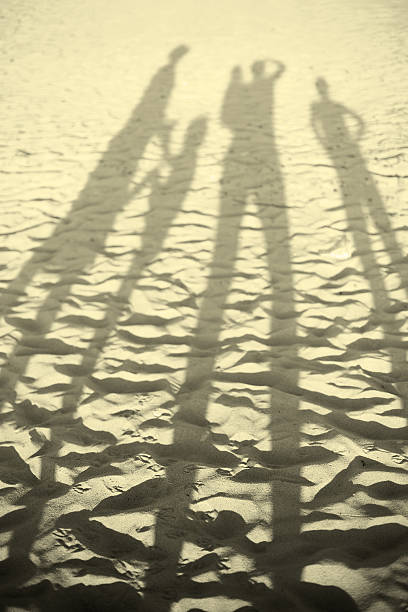 happy large family on beach sunset shadows happy large family on beach sunset shadows big family sunset stock pictures, royalty-free photos & images