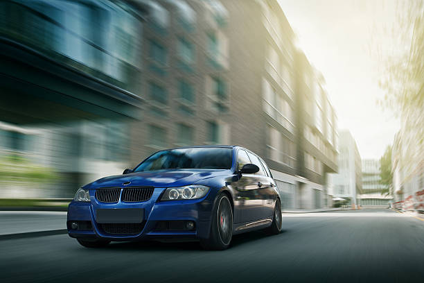 Blue car BMW E90 fast speed drive on city road stock photo