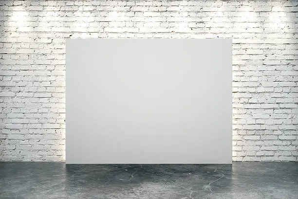 Photo of Blank white canvas in the center of white brick wall