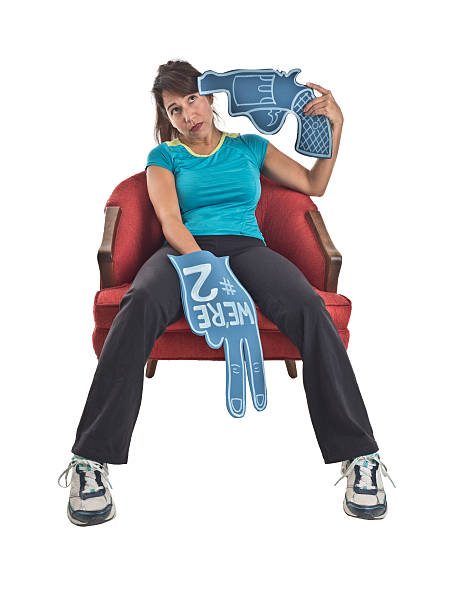 Sports Fan with Foam Finger Holds Foam Gun to Head stock photo