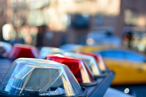 Police car emergency lights close up with NYC taxi in the background