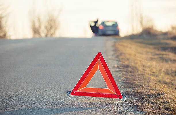 istock Red warning triangle on a road with a failure car 503590666