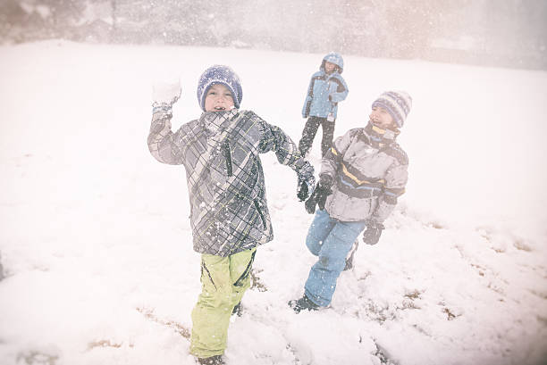 istock snow ball fight a child throws a snowball 503591090