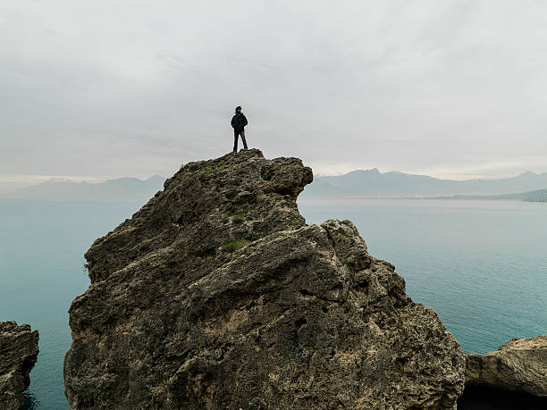 Man standing alone top of cliff