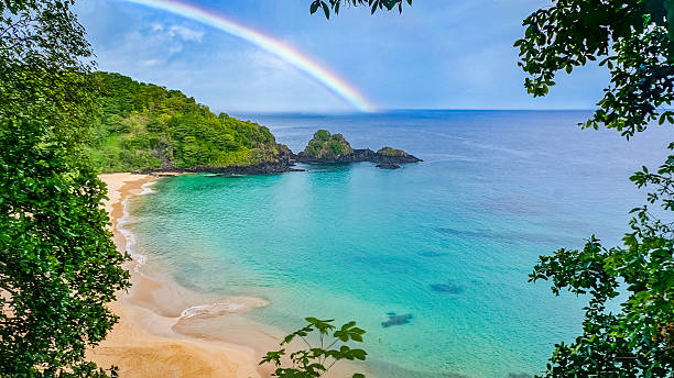 радуга в praia do "санчо" beach, фернандо де норонья, бразилия - beach sand стоковые фото и изображения