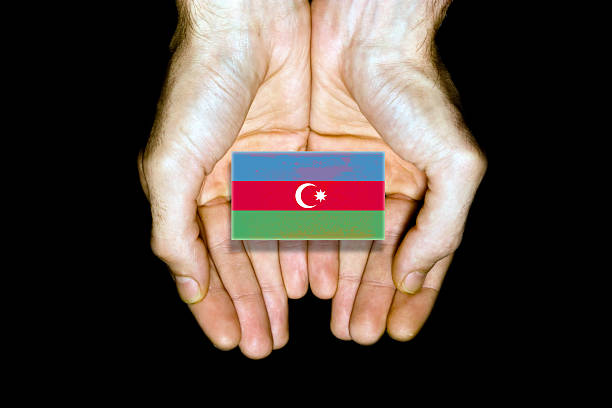 Flag of Azerbaijan in hands isolated on black background.