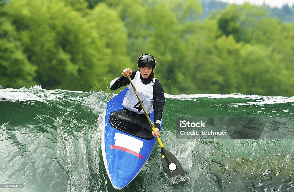 Young Female Canoeist Starting the Race Front view of young female competitor starting the race, canoe, slalom Rapids - River Stock Photo