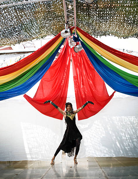 Male Drag Queen performs in front of Gay rainbow flag stock photo