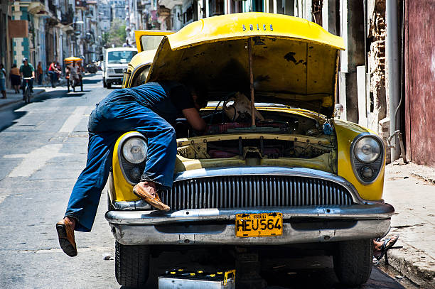 Mechanic working on his vintage Buick in Havana stree stock photo