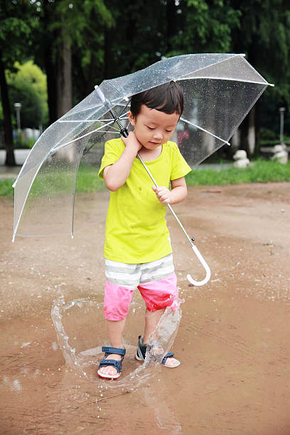 かわいい公園で遊ぶお子様 - rain drenched one person standing ストックフォトと画像