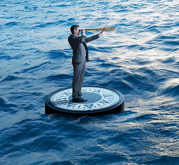 istock Businessman Standing On Compass Looks Through Spyglass 503619874