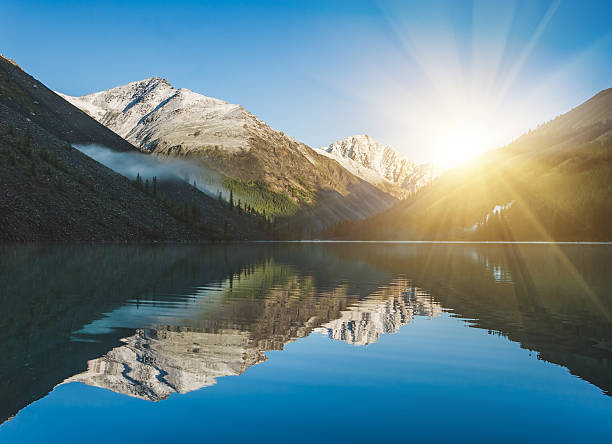 istock Sunrise and mountains reflected in the water 503620254