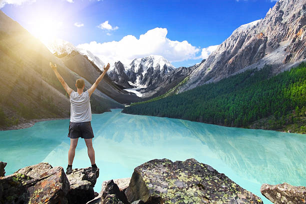 istock Hiker standing with raised hands near the beautiful mountain lak 503620278